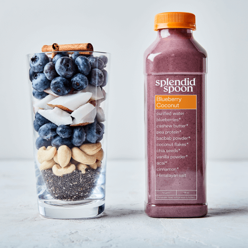 Cup of blueberries, coconut meat, cashews, chia seeds, cinnamon sticks and blueberry coconut smoothie in bottle on white background. 