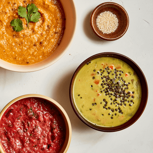 Cumin Sweet Potato Puree Soup, Red Beet Quinoa Grain Bowl, Carrot Lentil Curry Soup ON WHITE BACKGROUND WITH SMALL BOWL OF SEEDS.