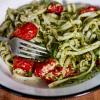 A close-up photo of Kale Pesto Noodles with a fork in the dish.