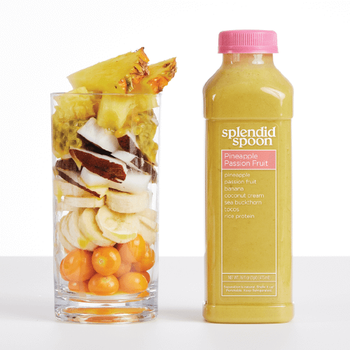 A clear glass filled with ingredients of the Pineapple Passion Fruit smoothie: pineapple, passion fruit, coconut, bananas, and sea buckthorn berry