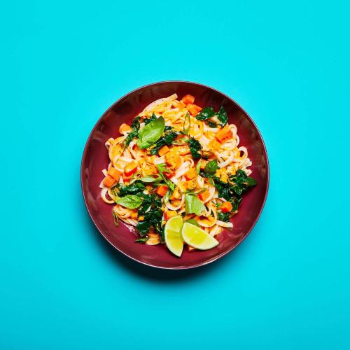 Red Curry Noodles in a dish on a blue background.