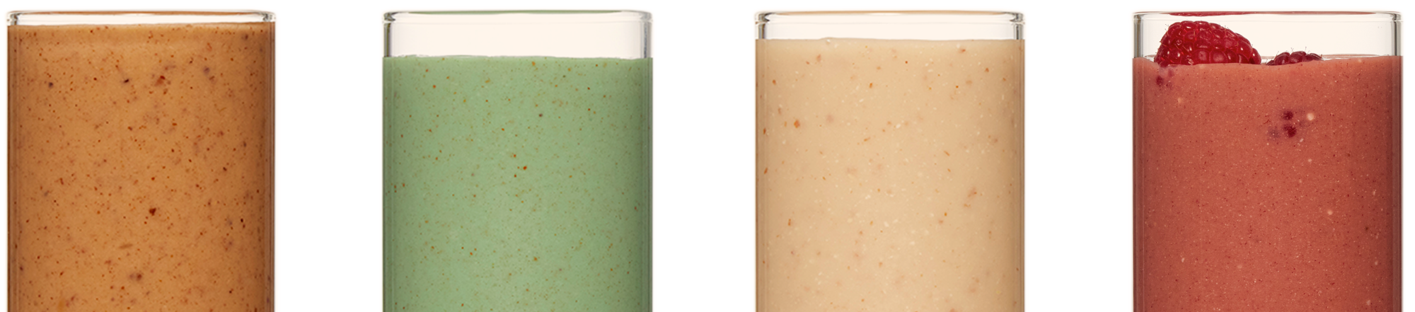Four clear classes filled with smoothies. The smoothies are redish brown, green, beige, and red from left to right. The rightmost smoothie is garnished with two raspberries.