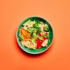 Tangy Ginger Noodles in a dish on an orange background.